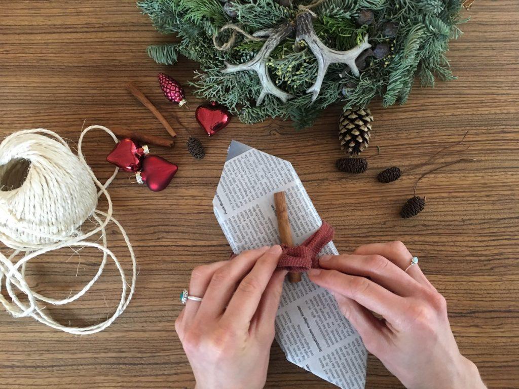 Geschenk in Zeitungspapier weihnachtlich dekoriert. © Green Pearls