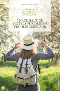 Rucksacktouristin genießt das Sonnenlicht in einem blühenden Kirschgarten