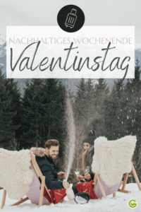 Ein Paar feiert den Valentinstag in den verschneiten Bergen, auf Liegestühlen sitzend, in Decken gehüllt. Der Mann verspritzt freudig Champagner. Der Text lautet „Nachhaltiges Wochenende zum Valentinstag“.