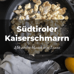 Eine Pfanne mit goldbraunem Kaiserschmarrn, bestäubt mit Puderzucker. Daneben liegen eine Zitrone, eine Reibe und Küchenutensilien auf einem Tuch. Der Text lautet „Südtiroler Kaiserschmarrn“.