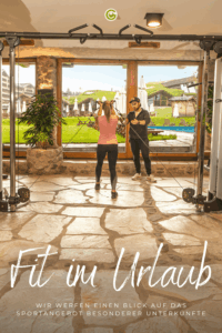 Zwei Personen trainieren mit Fitnessbändern in einem Raum mit großen Fenstern, durch die eine grüne Außenanlage mit Sonnenschirmen sichtbar ist, darunter der Text 'Fit im Urlaub' und 'Wir werfen einen Blick auf das Sportangebot besonderer Unterkünfte'