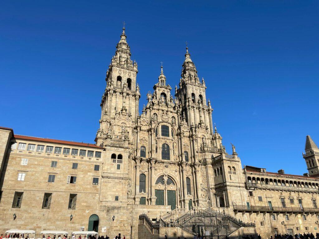Dieses Bild zeigt die atemberaubende Westfassade (Fachada do Obradoiro) der Kathedrale von Santiago de Compostela in Spanien. Sie ist die traditionelle Endstation des berühmten Pilgerwegs „Camino de Santiago“ (Jakobsweg)
