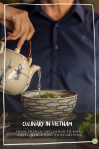 A person pours liquid from a teapot into a bowl of green herbs