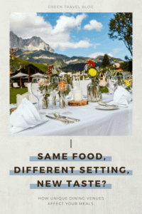 A festively set table with white napkins, glasses, and small vases of flowers against a mountain backdrop in a sustainable hotel garden
