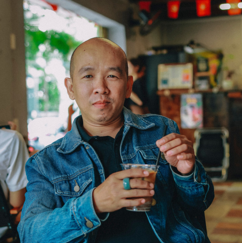 Mann in einem Cafe in Vietnam mit Kaffee in der Hand