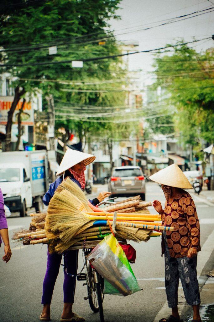 2 Vietnamesen mit traditionellen Hüten und einem Fahrrad