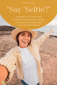 Eine junge Frau mit beigem Hut und hellem Pullover steht auf einem felsigen Küstenweg und streckt einen Arm aus, als würde sie ein Selfie machen. Im oberen Bildbereich befindet sich ein gelber Kreis mit weißem Text. Der Hintergrund zeigt das Meer und einen bewölkten Himmel.