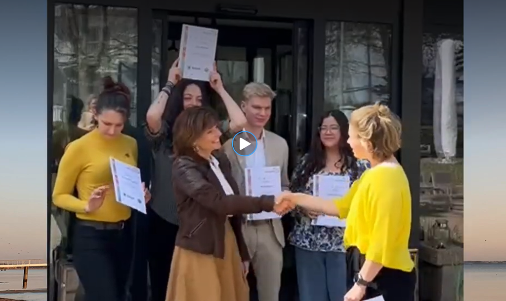 Screenshot vom Video über SDG Scouts vom Hotel SANDnature an der Ostsee Deutschland. Azubis und Hotelchefin nehmen Urkunden entgegen.