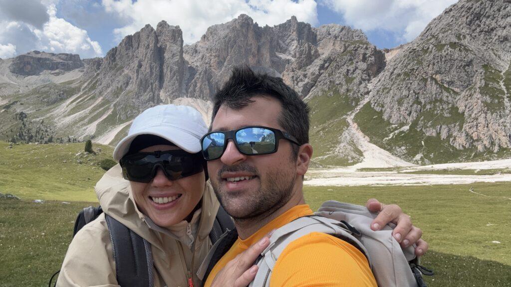 Selfie from a couple in the Dolomites, Man and Feemale happy with Selfie-Stick reflecting in the sunglasses.